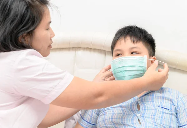 Moeder dragen bescherming masker zoon om te beschermen tegen griep vir — Stockfoto