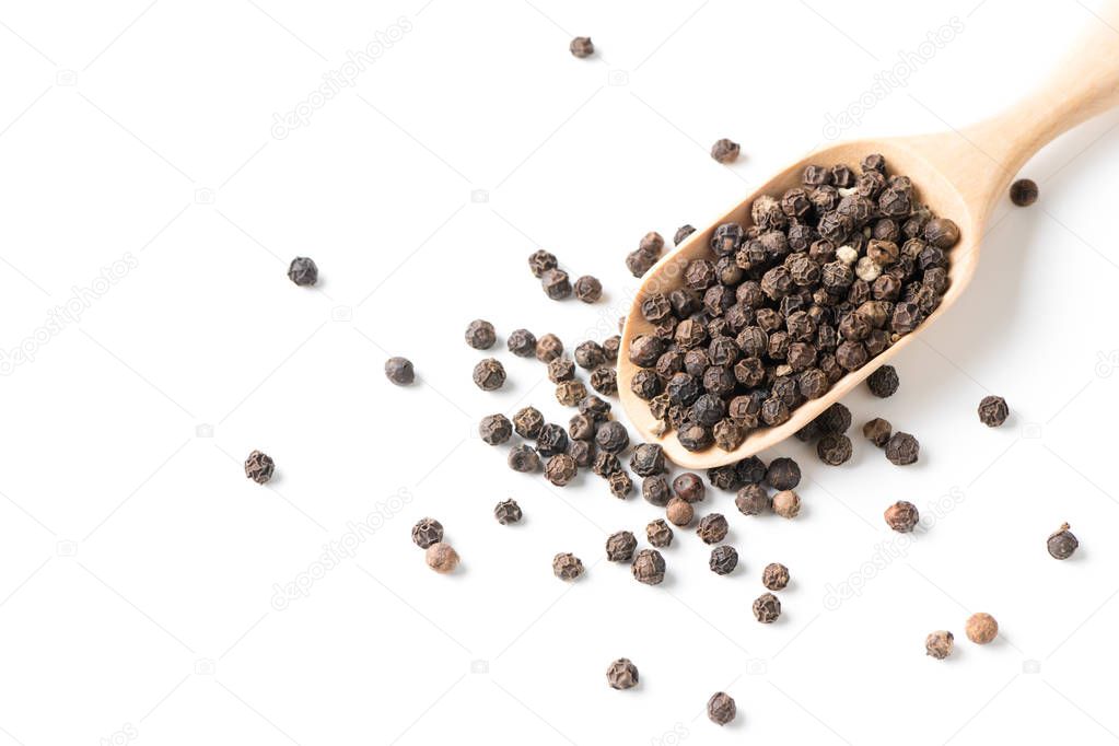 Dry black pepper on wood scoop isolated 