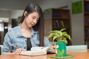 öğrenci üniversite kitaplığında okuma kitabı açın