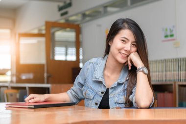 Kütüphanede emin gülümseyen öğrenci Asyalı kız 