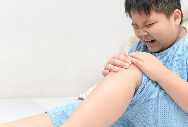 Niño gordo obeso que sufre de dolor de rodilla —  Fotos de Stock