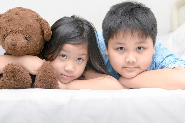Sorella e fratello sdraiato sul letto — Foto Stock