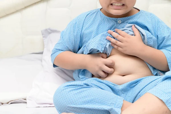 Scratching his belly in obese boy on bed — Stock Photo, Image