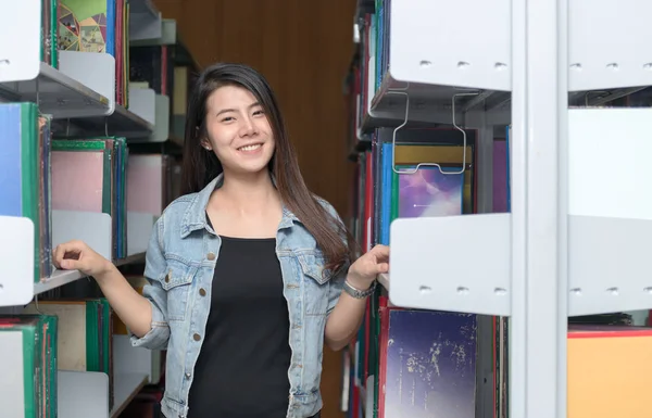 귀여운 학생 미소 도서관에 있는 책장과, — 스톡 사진