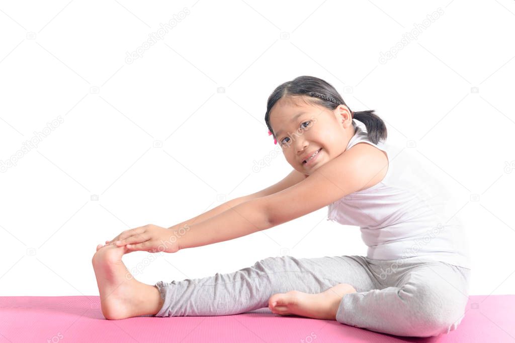 asian kid exercise on yoga mat isolated 