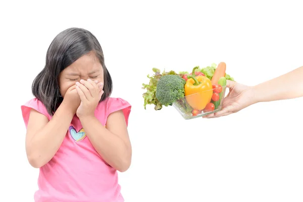 Menina com expressão de nojo contra legumes — Fotografia de Stock