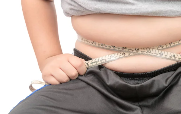 Niño gordo echa un vistazo a su grasa corporal con cinta métrica — Foto de Stock