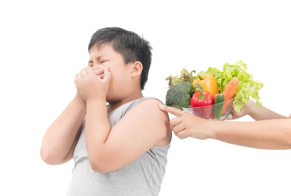 Menino com expressão de nojo contra legumes — Fotografia de Stock