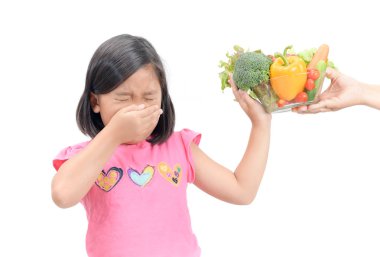 girl with expression of disgust against vegetables  clipart