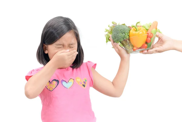 Menina com expressão de nojo contra legumes — Fotografia de Stock