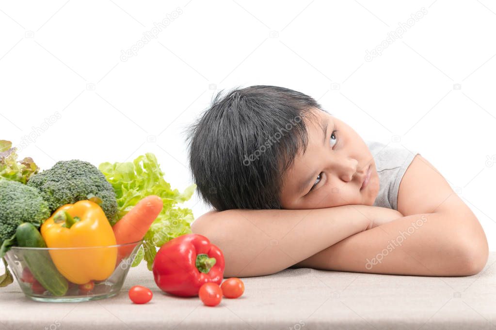 boy with expression of disgust against vegetables 
