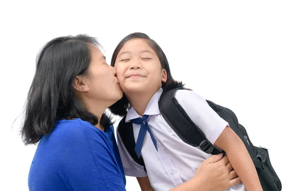 Madre bacio sua figlia in uniforme studente — Foto Stock