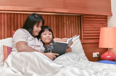 genç anne kızına bir kitap okuma. 