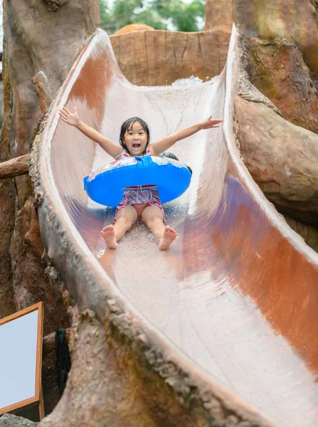 Feliz asiático chica jugar agua slider — Foto de Stock