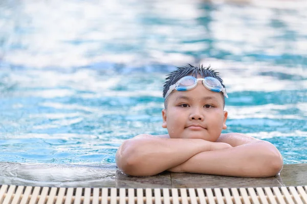 Fettleibige dicke Junge tragen Schutzbrille und lächeln im Schwimmbad, — Stockfoto
