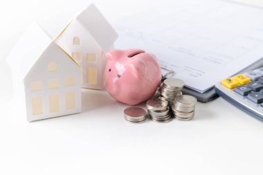 Parası ve kumbarası olan bir kağıt ev modeli. 