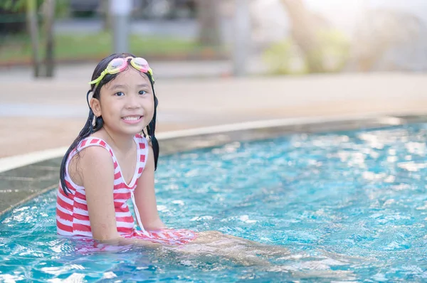 Menina usar óculos e sorrir na piscina , — Fotografia de Stock