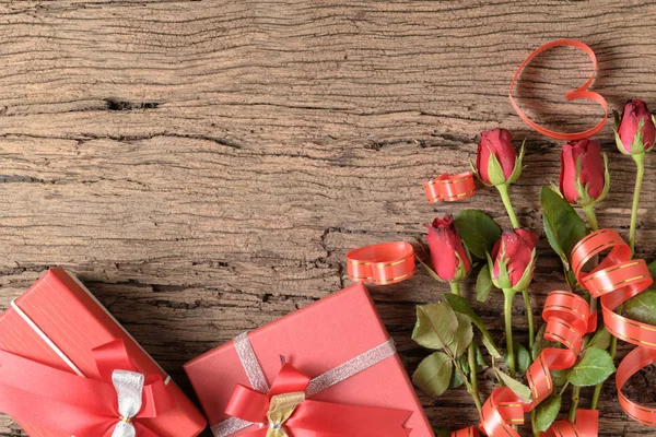 Red gift box with red roses and heart ribbon — Stock Photo, Image