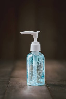 COVID-19 veya Coronavirus konseptini korumak için eski ahşap arka planda el dezenfektanı şişesi veya alkol jeli.