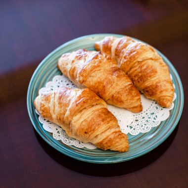 Mavi bir tabakta üç kruvasan