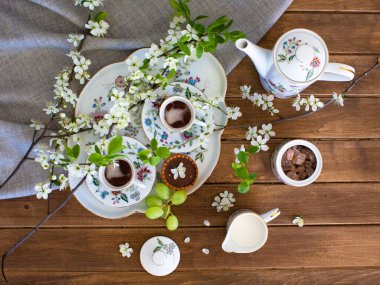 Çiçek ve üzümlü tepside iki fincan kahve.