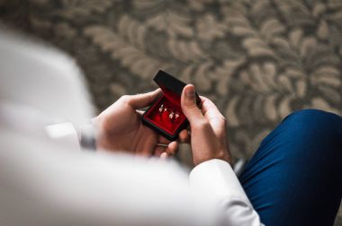 Damat ile altın alyans takı hediye kutusu tutar. Adam hediye kutusu ve nikah yüzüğü. Alyans damat elinde bir kutu içinde. Düğün Aksesuarları. Evlilik