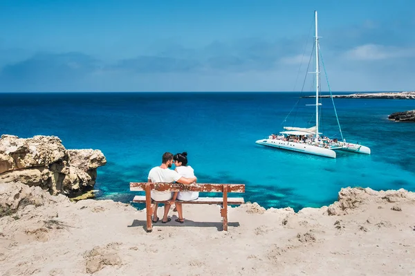 Bir çift bir bankta oturur ve lagün görünüyor. Balayı severler. Erkek ve kadın adada. Çift tatilde aşık. Bir cruise gezisi için bir fiş. Deniz turu. Balayı gezisi.