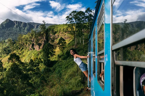 Güzel kız dağlar arasında trenle seyahat. Kız güzel yerlere trenle seyahat eder. Tren. Asya seyahat. Sri Lanka eğitiyor. Demiryolu taşımacılığı. Tren. Asya Nakliyat