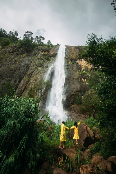 Zakochana Para Przy Wodospadzie Mężczyzna Kobieta Żółtych Płaszczach Przeciwdeszczowych Facet — Zdjęcie stockowe