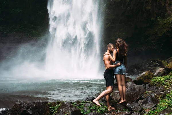 Man Athletic Build Kisses Beautiful Girl Waterfall Honeymoon Trip Declaration — Stockfoto