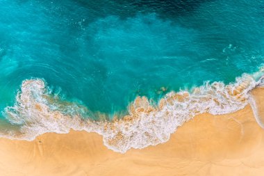 Endonezya, Bali 'deki Nusa Penida Adası' ndaki Kelinking sahilindeki turkuaz okyanus dalgalarının hava manzarası. Turkuaz denizi olan güzel kumlu bir sahil. Güzel dalgaları olan ıssız kumlu bir sahil. Endonezya plajları