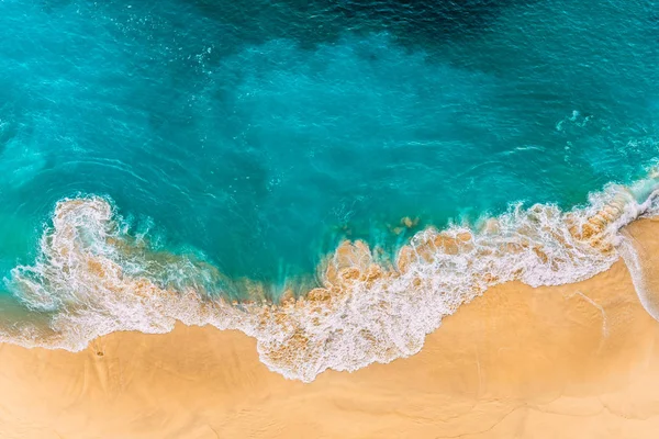 Endonezya, Bali 'deki Nusa Penida Adası' ndaki Kelinking sahilindeki turkuaz okyanus dalgalarının hava manzarası. Turkuaz denizi olan güzel kumlu bir sahil. Güzel dalgaları olan ıssız kumlu bir sahil. Endonezya plajları