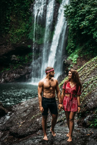 Atlético Segura Mão Uma Bela Mulher Numa Cascata Casal Apaixonado — Fotografia de Stock