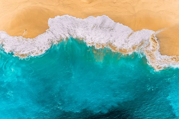 Kelingking plajındaki turkuaz okyanus dalgaları, Bali, Endonezya 'daki Nusa Penida Adası. Turkuaz denizi olan güzel kumlu bir sahil. Okyanus dalgaları kumlu sahile ulaşıyor. Endonezya plajları