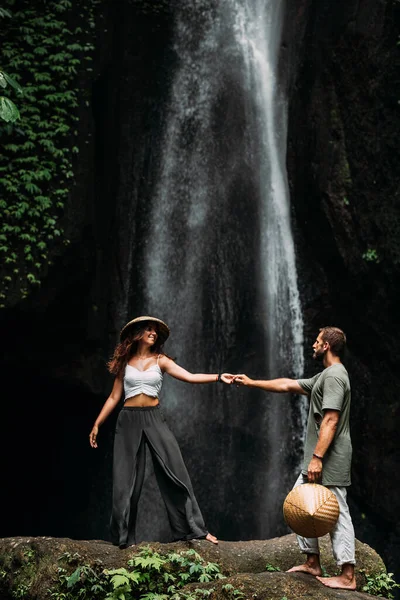 滝に恋をしているカップル 新婚旅行だ バリ島の幸せなカップル 美しいカップルは世界を旅する インドネシアへの旅行 休暇で幸せなカップル 結婚式の旅 スペースのコピー — ストック写真