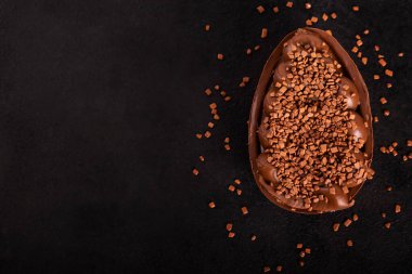 Siyah arka planda Paskalya için doldurulmuş çikolatalı yumurta. Seçici odak