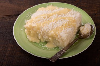 Brezilya geleneksel tatlısı: Tahta üzerinde hindistan cevizi olan tatlı kuskus (tapyoka) pudingi. Seçici odak