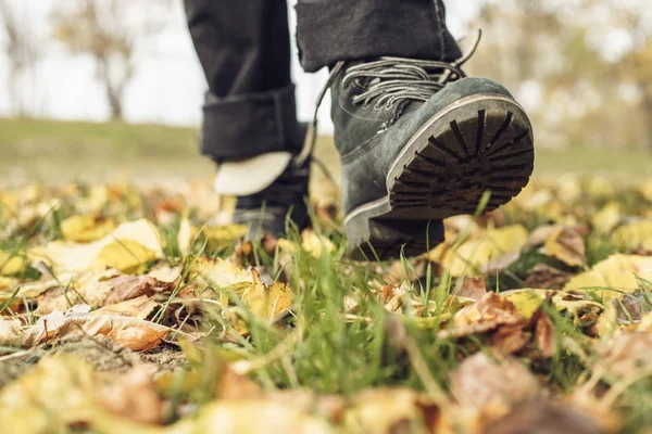 Pés botas folhas de outono — Fotografia de Stock