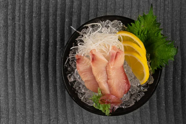 Sashimi tonijn met schijfje citroen verse Groenen op bamboe blad en in de plaat vol met ijs. — Stockfoto