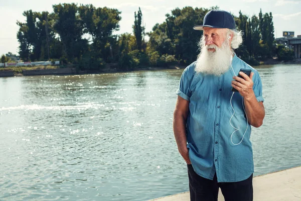 Vousatý Stylový Dospělý Muž Sluchátkách Poslouchá Hudbu Pomocí Chytrého Telefonu — Stock fotografie