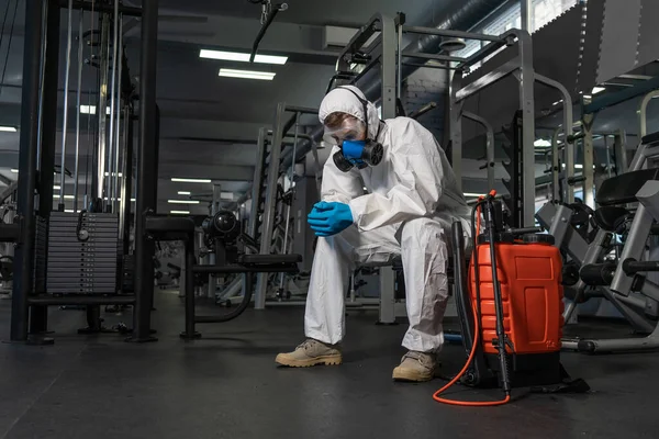 プロの消毒剤個人用保護具銅スーツ マスク 加圧スプレー消毒水でジムのスペースを掃除してCovid 19コロナウイルスを除去する — ストック写真