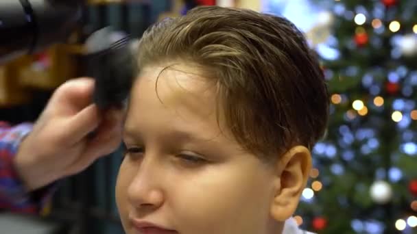 美容師は男の子の頭にはさみで髪をカットします バックビュー スタイリストの手のクローズアップ — ストック動画