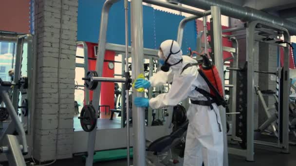 Trabalhador Desinfeta Equipamento Fitness Ginásio Coronavírus Covid Perigo Com Antibacteriano — Vídeo de Stock