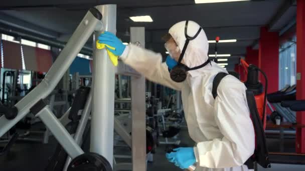 Werknemer Desinfecteert Fitnessapparatuur Van Coronavirus Covid Gevaar Met Antibacteriële Reinigingsmiddel — Stockvideo