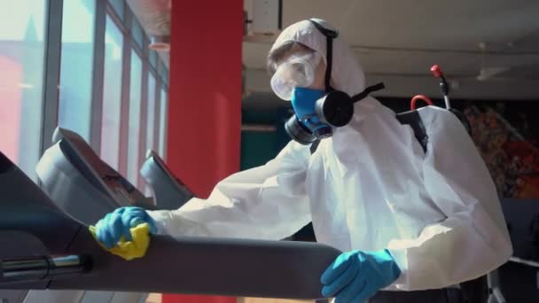Werknemer Desinfecteert Fitnessapparatuur Van Coronavirus Covid Gevaar Met Antibacteriële Reinigingsmiddel — Stockvideo