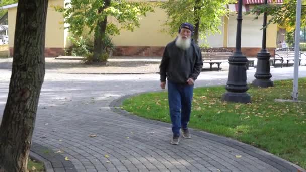 Senior Man Listens Music Walking Autumn Park — Stock Video