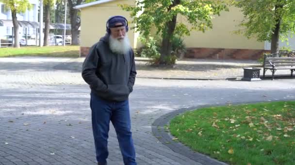 Senior Man Luistert Muziek Wandelen Herfst Park — Stockvideo