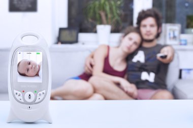 Genç anne bebek monitörde sakin iken Tv izlerken