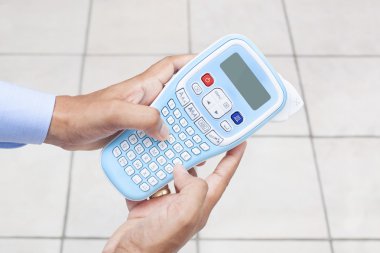 El Label Maker Makina kullanan adam
