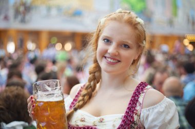 Geleneksel dirndl giyen ve 1 litre bira stein Ekim Festivali'nde holding neşeli genç kadın portresi